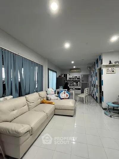 Spacious living room with modern decor and cozy seating area, perfect for relaxation and entertainment.