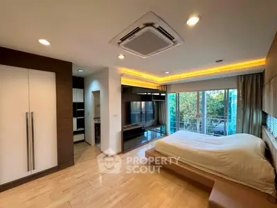 Spacious modern bedroom with balcony and stylish lighting