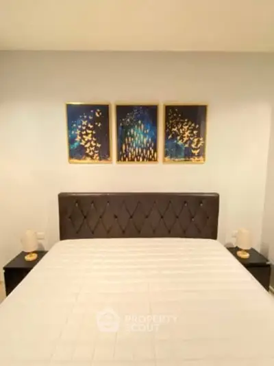Modern bedroom with elegant decor and stylish artwork above bed