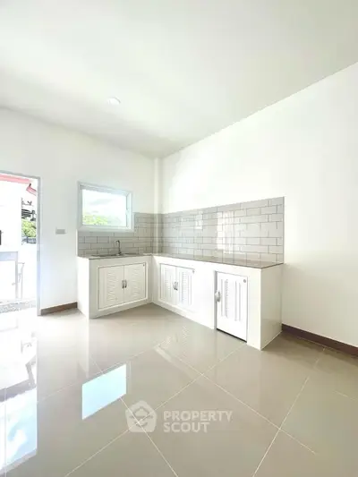 Bright modern kitchen with sleek white cabinets and glossy tiled floor, perfect for culinary enthusiasts.