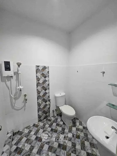 Modern bathroom with stylish tile design and essential fixtures.