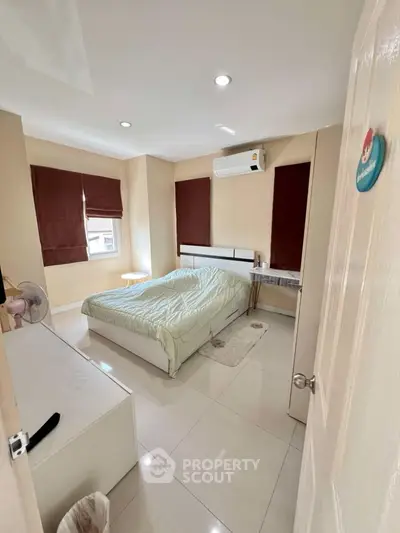 Cozy bedroom with air conditioning and natural light, perfect for relaxation.