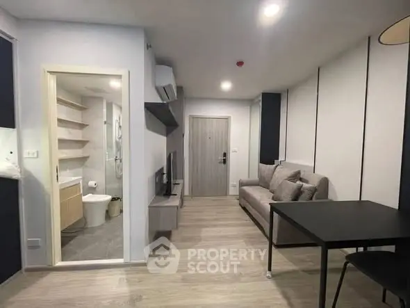 Modern apartment interior with open living area and bathroom view