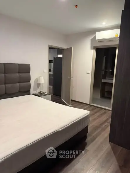 Modern bedroom with stylish decor and wooden flooring in a contemporary apartment.