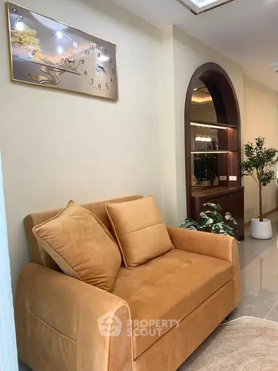 Cozy living room with plush sofa and elegant wall decor in modern apartment.