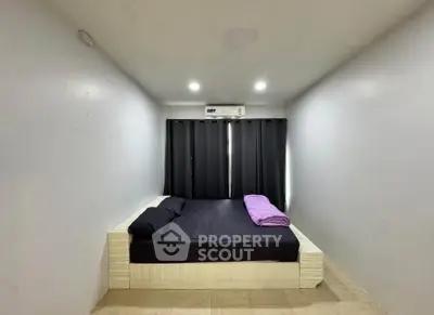 Minimalist bedroom with modern design and cozy ambiance, featuring a comfortable bed and sleek decor.
