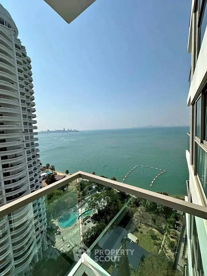 Stunning ocean view from high-rise balcony overlooking pool and city skyline.