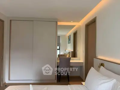 Modern bedroom with sleek design, featuring a built-in wardrobe and stylish vanity area.