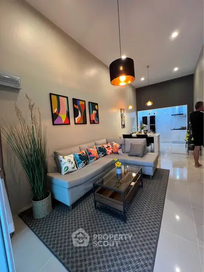 Modern living room with stylish decor and open layout leading to kitchen area.