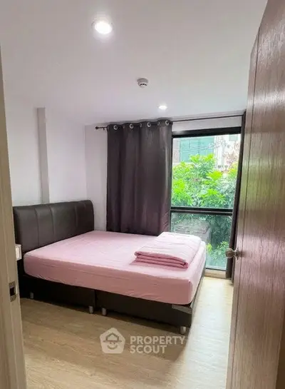 Cozy bedroom with large window and modern decor in urban apartment