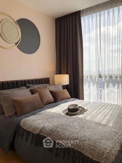 Cozy bedroom with stylish decor and large window offering natural light