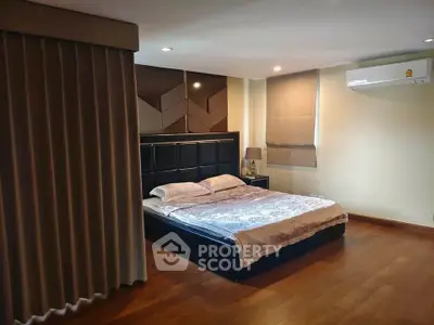 Spacious bedroom with modern decor and wooden flooring