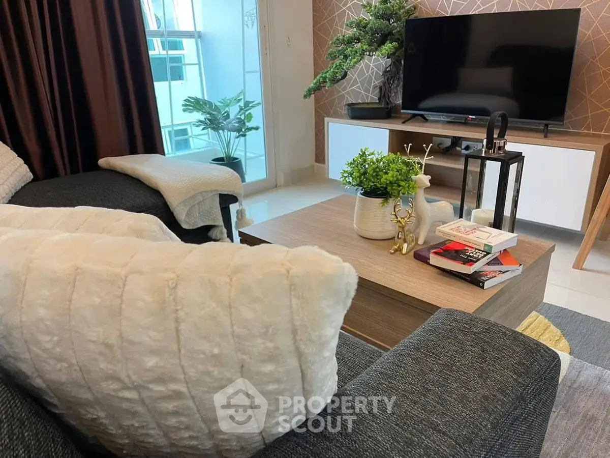 Cozy living room with modern decor, plush sofa, and flat-screen TV for ultimate relaxation.