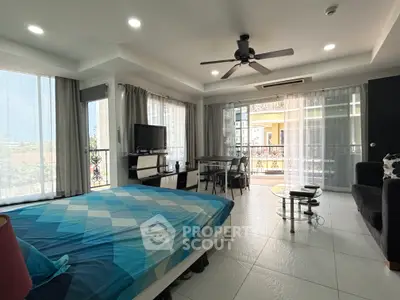 Spacious modern bedroom with large windows and balcony access, featuring stylish decor and ample natural light.