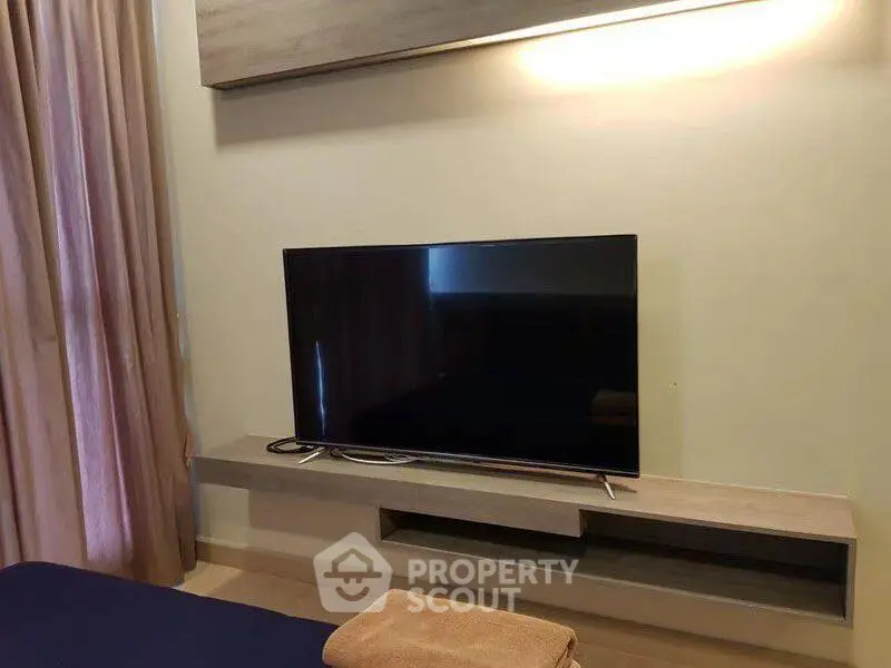 Modern living room with sleek TV setup and elegant curtains
