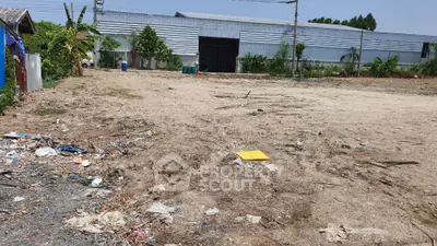 Vacant land plot with potential for development, featuring open space and surrounding greenery.