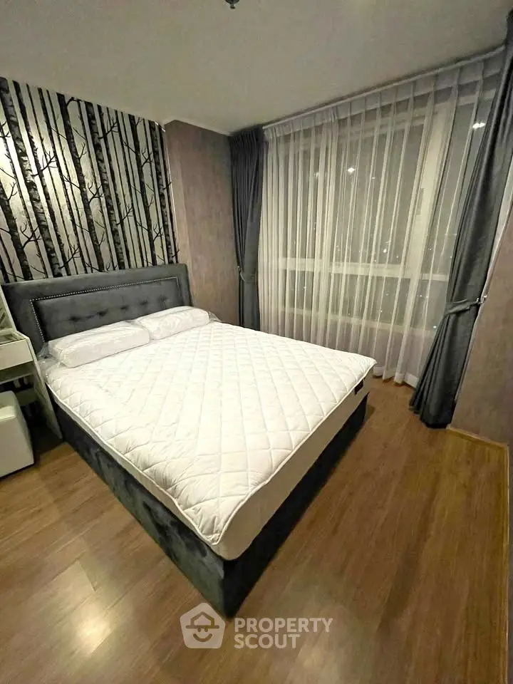 Modern bedroom with stylish decor and large window, featuring elegant curtains and a comfortable bed.
