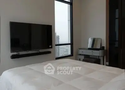 Modern bedroom with city view, wall-mounted TV, and sleek furniture