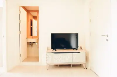 Modern living room with TV and bathroom entrance, minimalist design