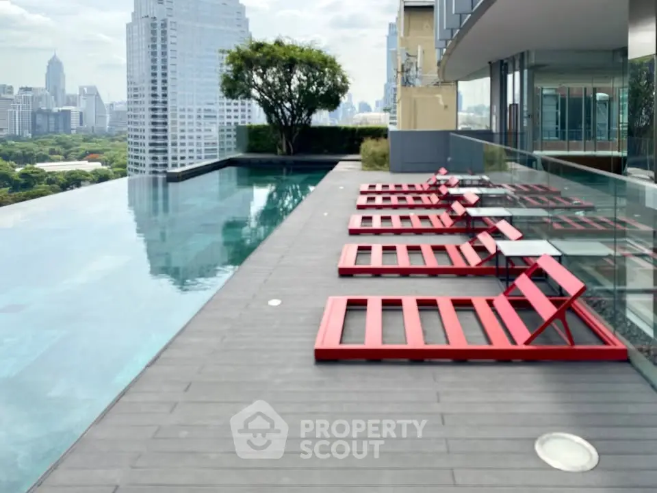 Luxurious rooftop pool with stunning city views and modern red loungers.