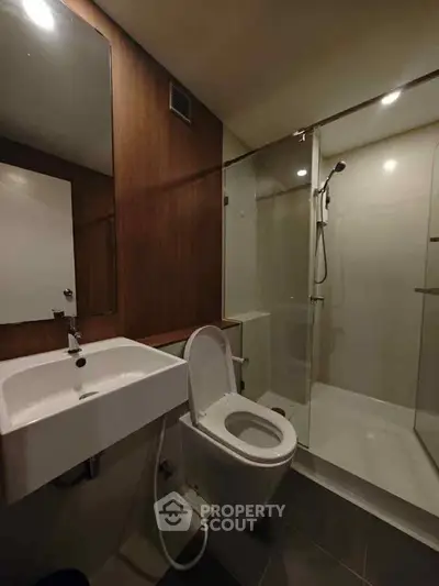 Modern bathroom with glass shower and sleek fixtures in a contemporary home.