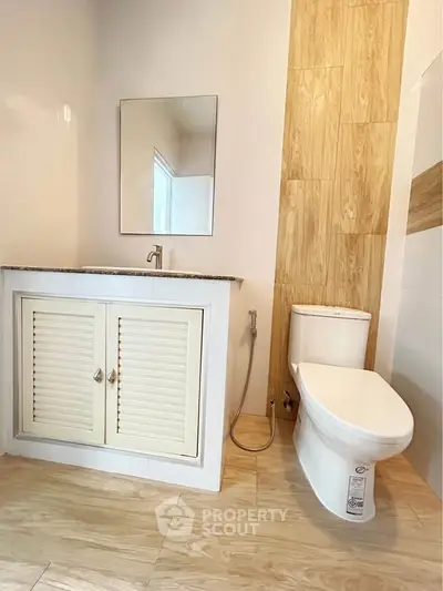 Modern bathroom with sleek fixtures and wooden accents for a cozy feel.