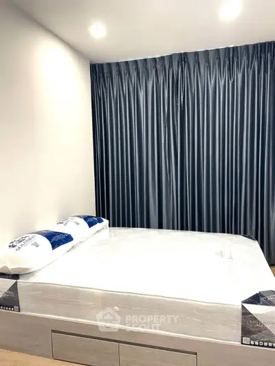 Modern bedroom with sleek design and luxurious bedding, featuring elegant dark curtains.