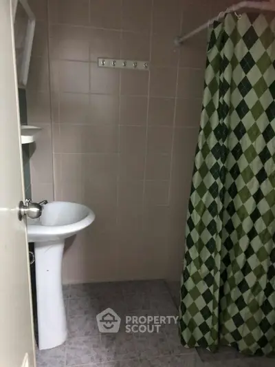 Cozy bathroom with pedestal sink and checkered shower curtain