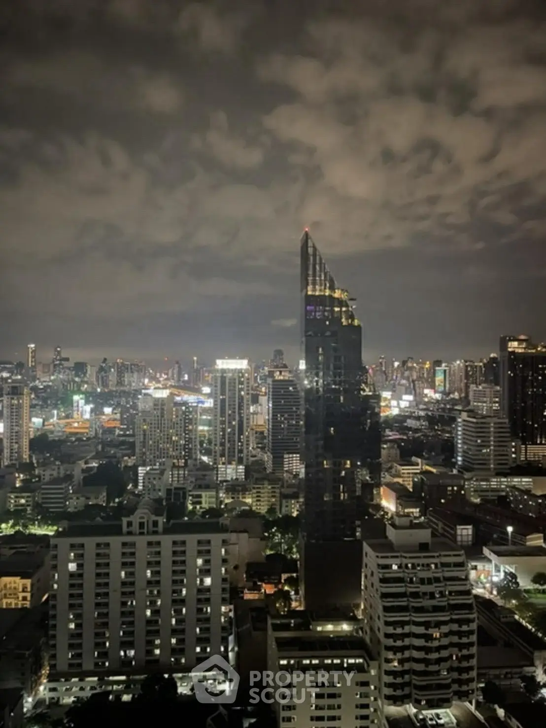 Stunning cityscape view from high-rise building at night with illuminated skyline.