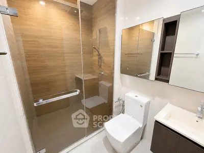 Modern bathroom with glass shower and sleek fixtures in contemporary apartment.