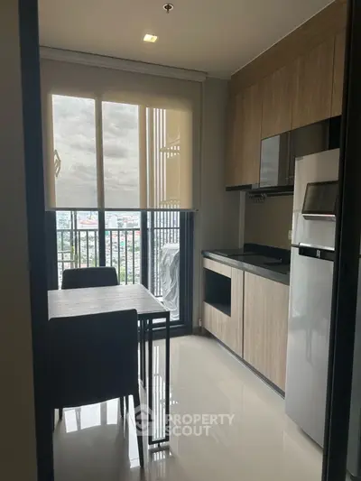 Modern kitchen with sleek cabinetry and balcony view, perfect for urban living.