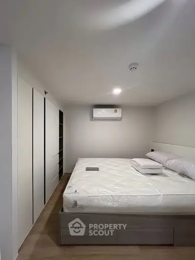Modern bedroom with sleek design, featuring a spacious bed and built-in wardrobe.