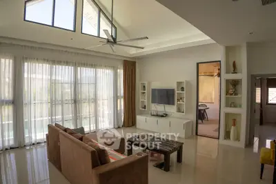 Spacious modern living room with high ceilings and large windows, perfect for natural light.