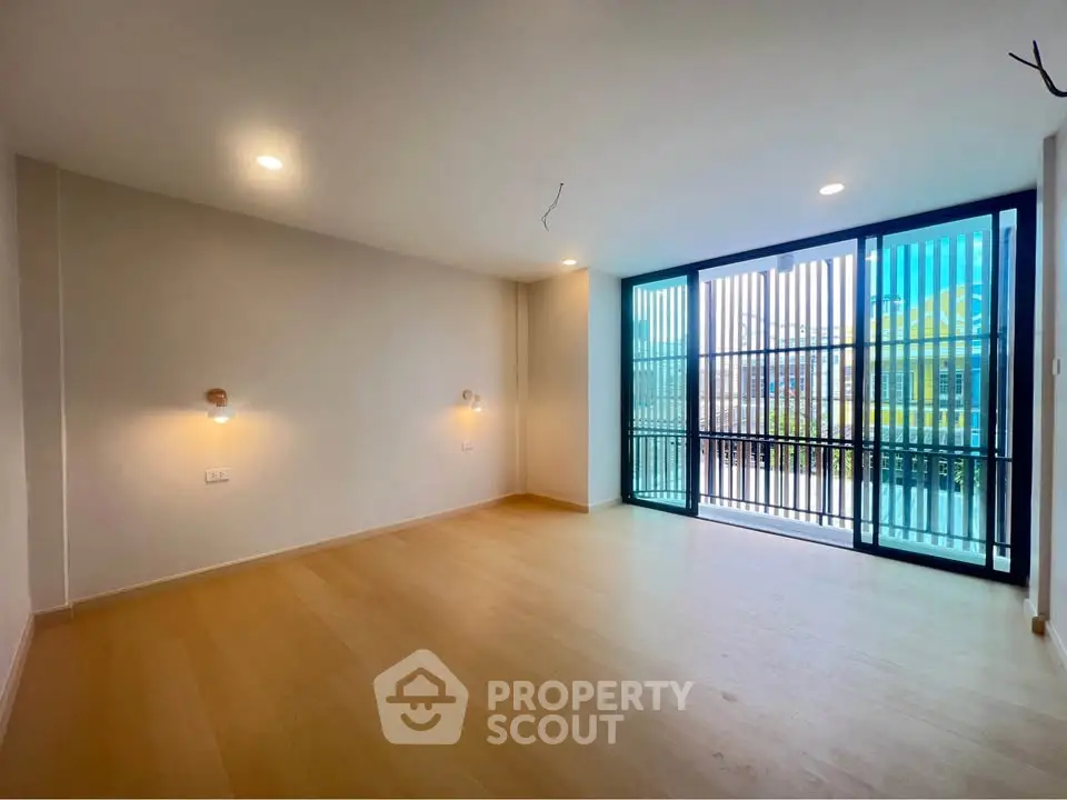 Spacious modern living room with large windows and wooden flooring, perfect for natural light lovers.