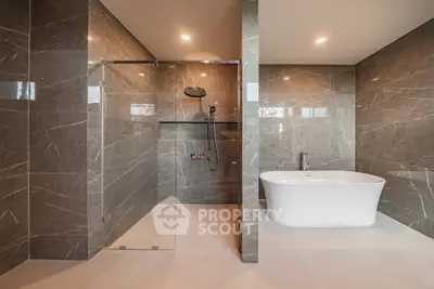 Luxurious modern bathroom with elegant marble tiles and freestanding bathtub.