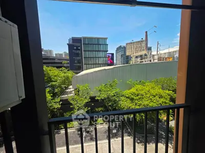 Urban balcony view with modern buildings and lush greenery