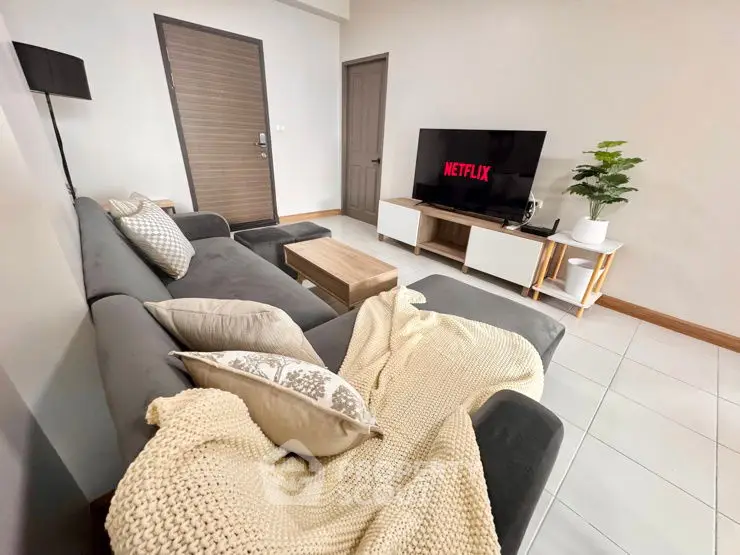 Modern living room with cozy sofa and TV setup, perfect for relaxation.