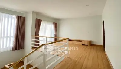 Spacious and bright living area with modern wooden flooring and large windows.
