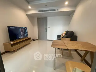 Modern living room with sleek furniture and large TV, perfect for relaxation and entertainment.