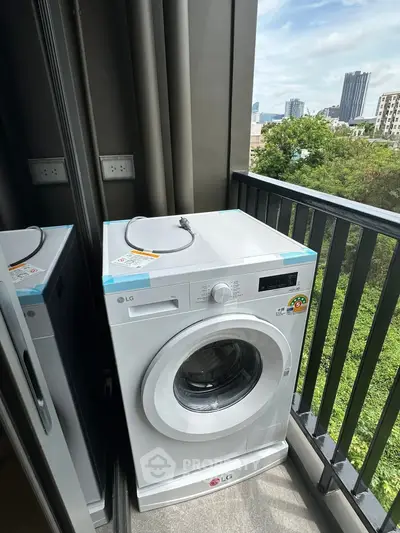 Compact balcony with washing machine and city view, perfect for urban living convenience.