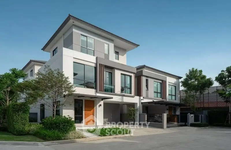 Modern two-story house with sleek design and lush greenery