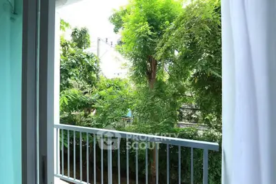 Charming balcony view with lush greenery, perfect for relaxation and enjoying nature.