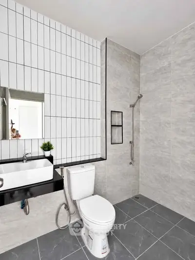 Modern bathroom with sleek design, featuring a shower and contemporary fixtures.