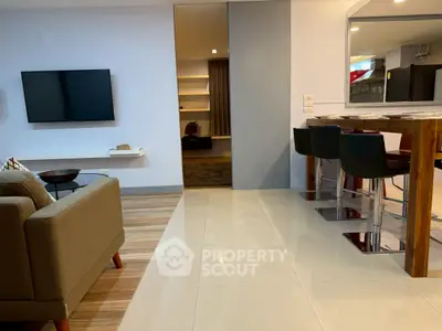 Modern living room with sleek TV setup and stylish dining area, perfect for contemporary living.
