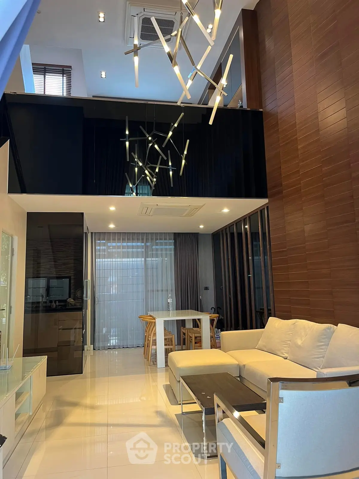 Luxurious modern living room with high ceiling and stylish lighting fixtures