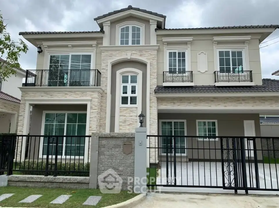 Elegant two-story house with modern facade and gated driveway