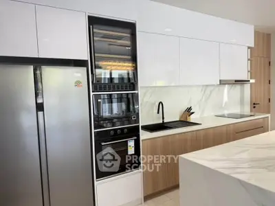 Modern kitchen with sleek appliances and marble countertops in a stylish open layout.