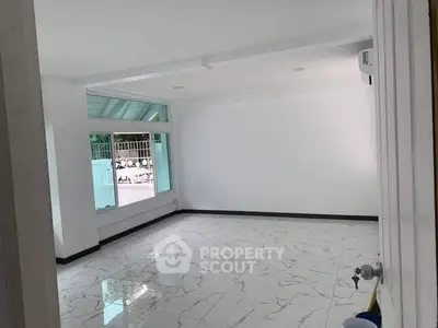 Spacious empty room with large window and marble floor tiles, perfect for customization.