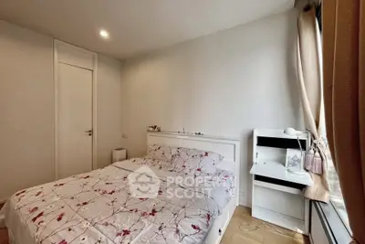 Cozy bedroom with floral bedding and natural light, perfect for relaxation.