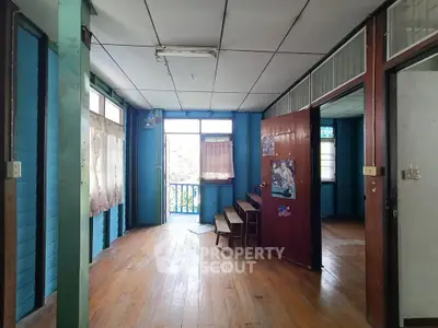Charming rustic interior with wooden floors and blue walls, featuring natural light and a cozy atmosphere.